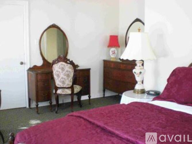 A bedroom with a bed, dresser, and chair.