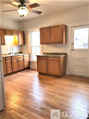 A kitchen with wooden cabinets and a ceiling fan.