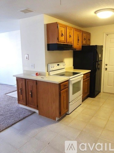 A kitchen with wooden cabinets and black appliances.