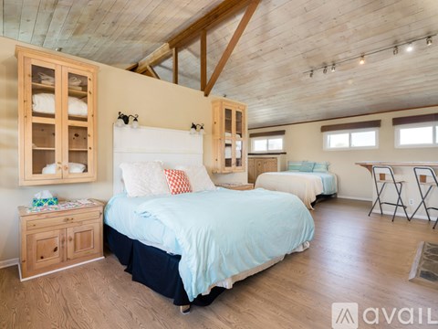 A bedroom with a large bed and wooden furniture.