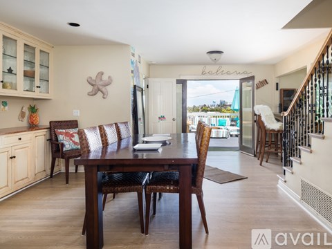 A dining room with a wooden table and chairs.