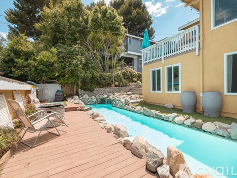 A backyard with a pool and deck.