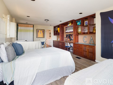 A bedroom with a large bed and a wooden cabinet.