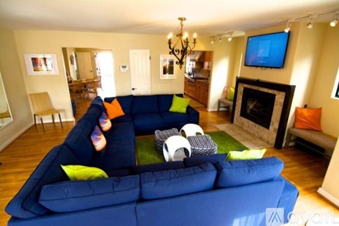 A blue couch with a green pillow in the middle of a living room.