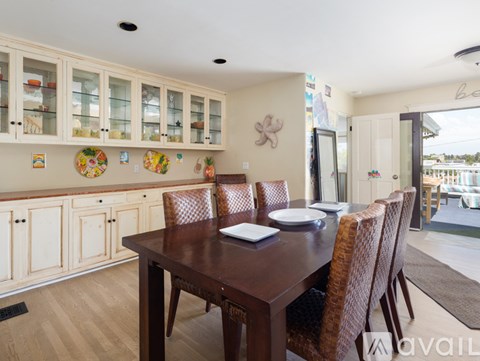 A dining room with a wooden table and chairs.