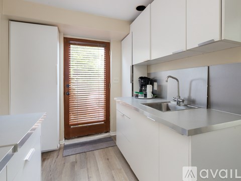 A kitchen with white cabinets and a white fridge.