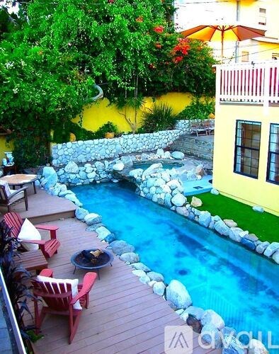 A small pool surrounded by rocks and a wooden deck.