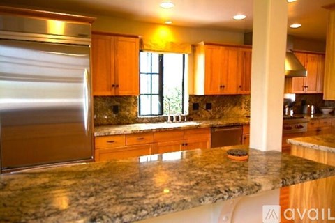 A kitchen with granite countertops and wooden cabinets.