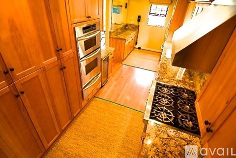 A kitchen with wooden cabinets and a stove top oven.