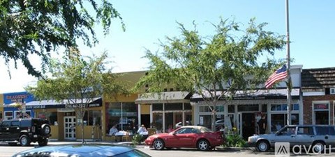 A car dealership with a red car in the foreground.