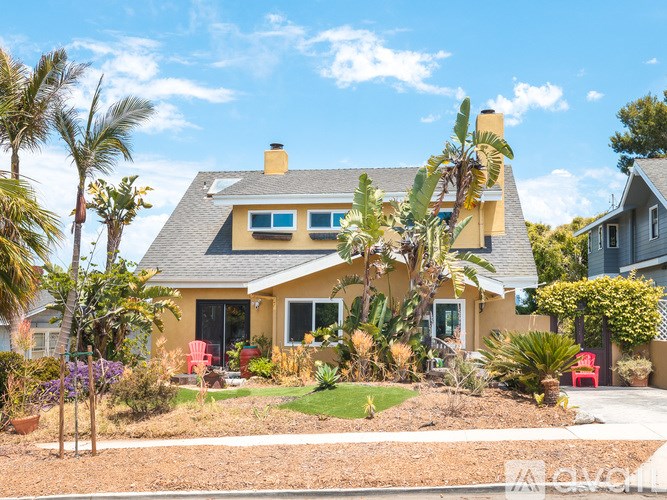 A yellow house with a red chair in front of it.