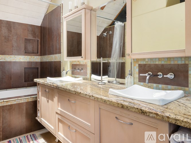 A bathroom with brown tiles and a marble countertop.