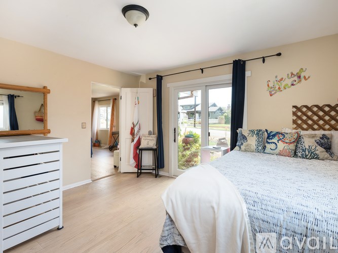 A bedroom with a bed, a dresser, and a mirror.