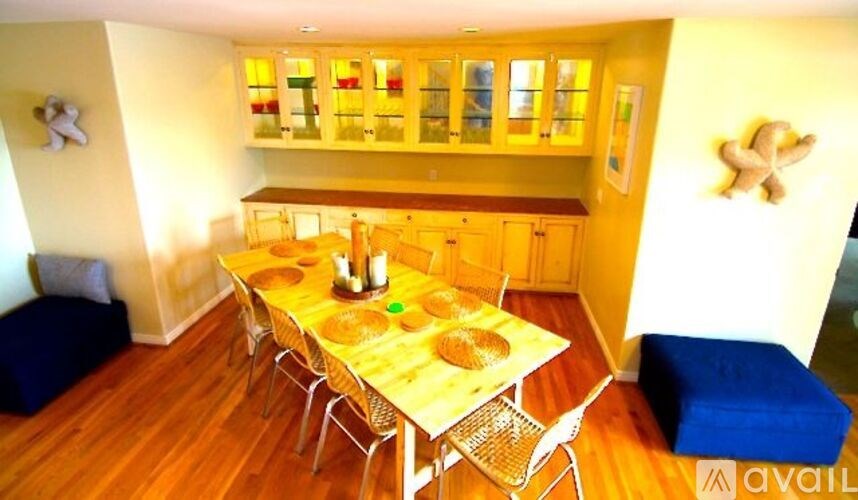 A dining room with a table set for two and chairs around it.