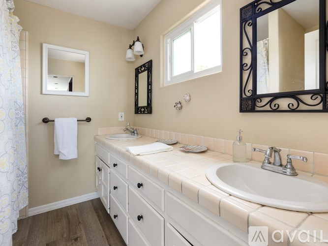 A bathroom with a white sink and a mirror above it.