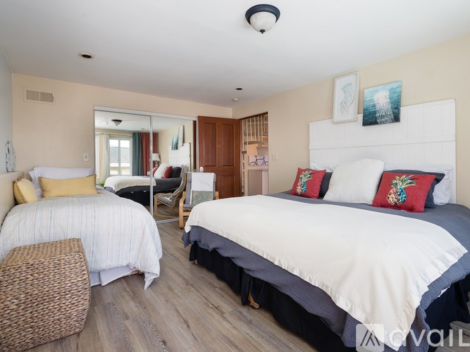 A bedroom with two beds and a chair.