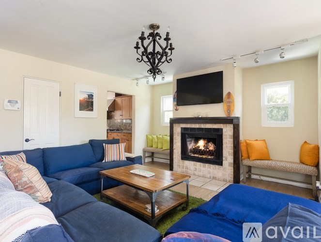 A living room with a blue couch and a fireplace.