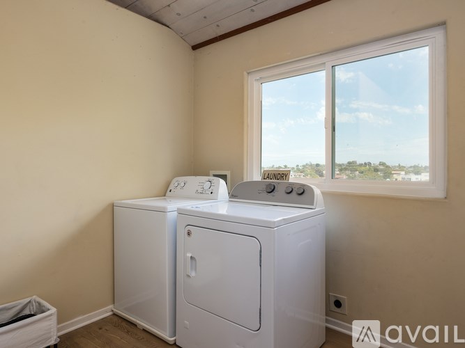 A laundry room with a washer and dryer and a window.