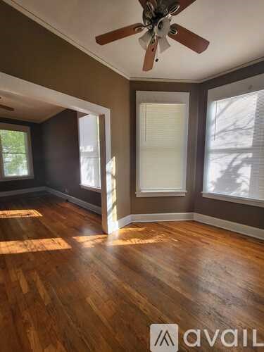 A room with wooden floors and a ceiling fan.