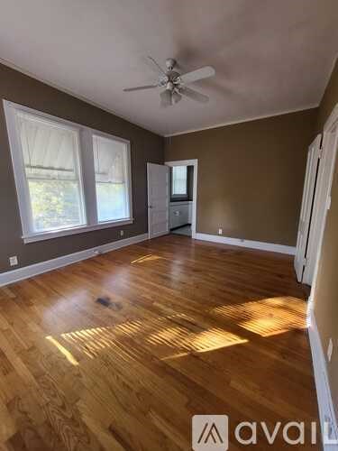 A room with wooden flooring and a ceiling fan.
