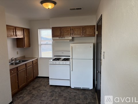 A kitchen with white appliances and wooden cabinets.