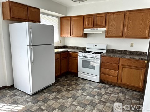 A kitchen with a white refrigerator and a white stove top oven.
