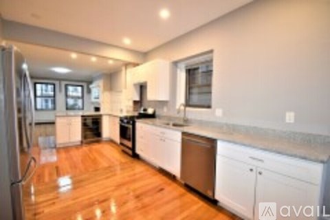 A kitchen with white cabinets and a wooden floor.