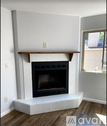 A white fireplace with a wooden mantle and a black firebox.