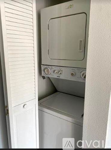 A white oven with a door open is in a kitchen.