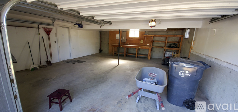 A large garage with a trash can and a table in it.