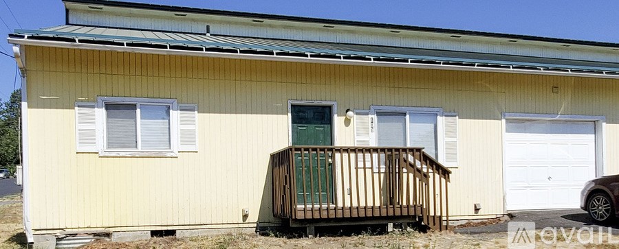A yellow house with a green door and a white garage door.