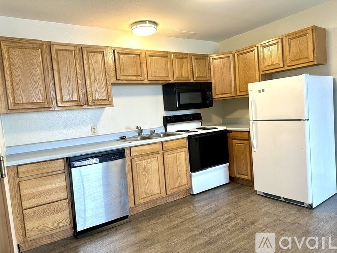 A kitchen with wooden cabinets and a white refrigerator.