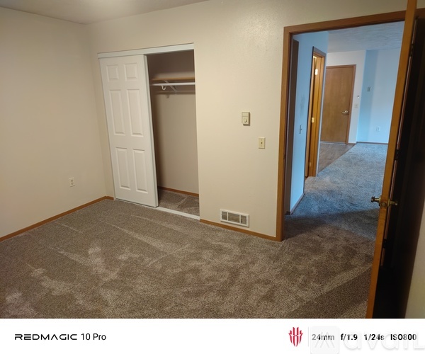 A room with wooden floors and a window with blinds.