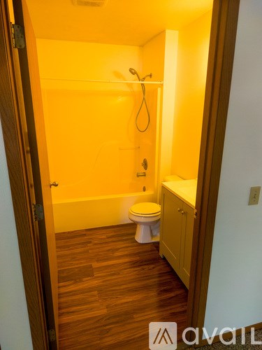 A room with a carpeted floor, a window with blinds, and a door.