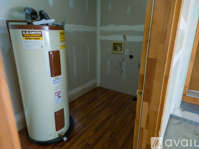 A room under construction with a ladder, paint cans, and a broom.