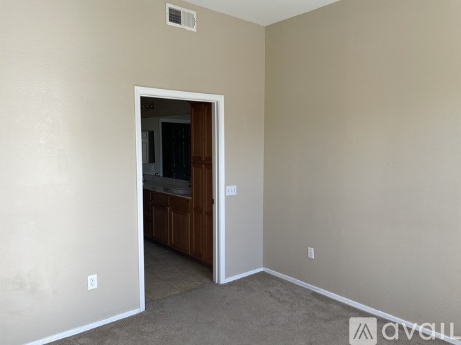 A room with a doorway leading to a kitchen.