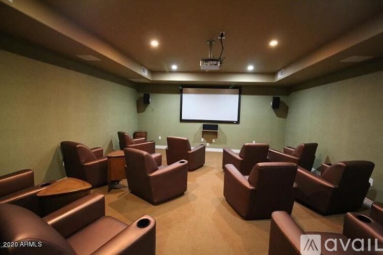 A home theater room with a screen and chairs.
