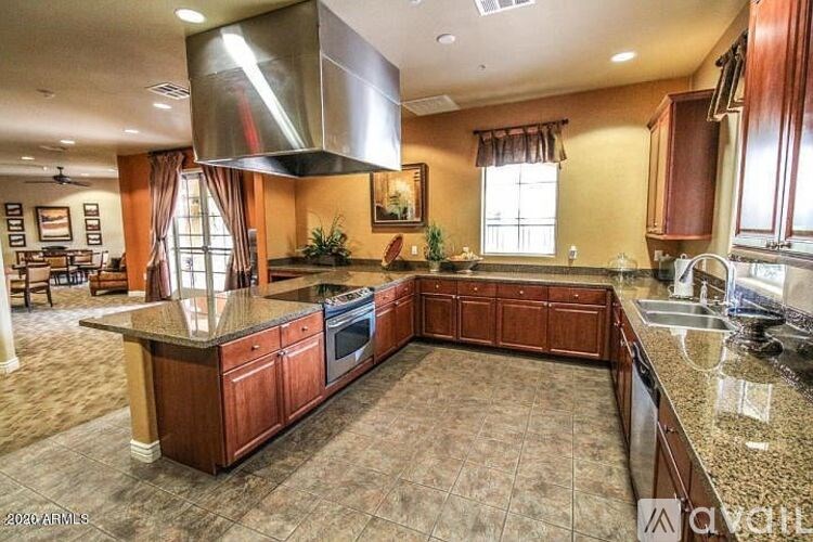 A kitchen with brown cabinets and a granite countertop.