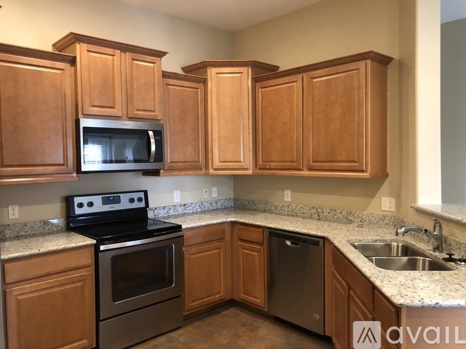 A kitchen with wooden cabinets and granite countertops.