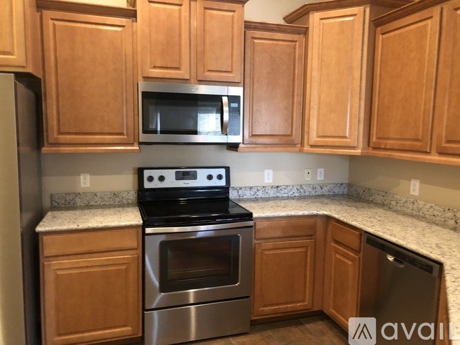 A kitchen with wooden cabinets and stainless steel appliances.