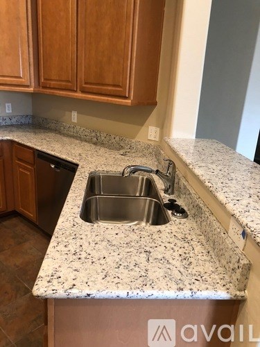 A kitchen with granite countertops and a double sink.