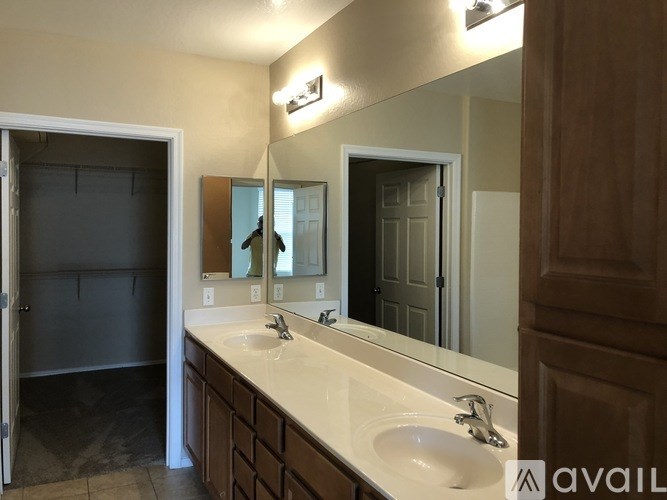 A bathroom with a sink, mirror, and a door.