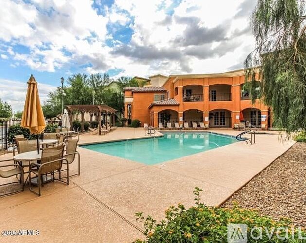 A large orange building with a pool in front.