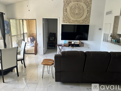 A living room with a black couch and a television.