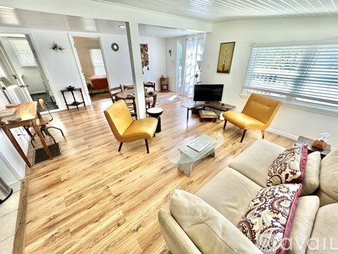 A living room with a yellow chair and a couch.