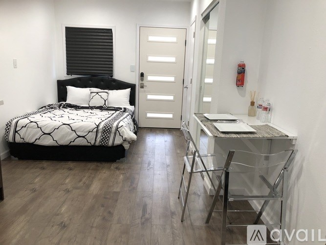 A bedroom with a bed, desk, and chair.