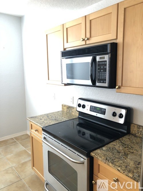 A kitchen with a black microwave and stove top oven.