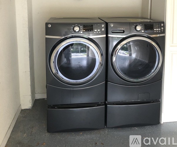 Two black front loading washing machines in a room.