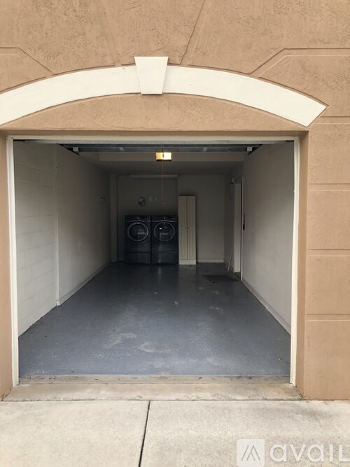 A garage with a concrete floor and a white archway.