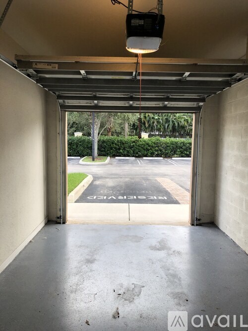 A parking lot is visible through the open garage door.